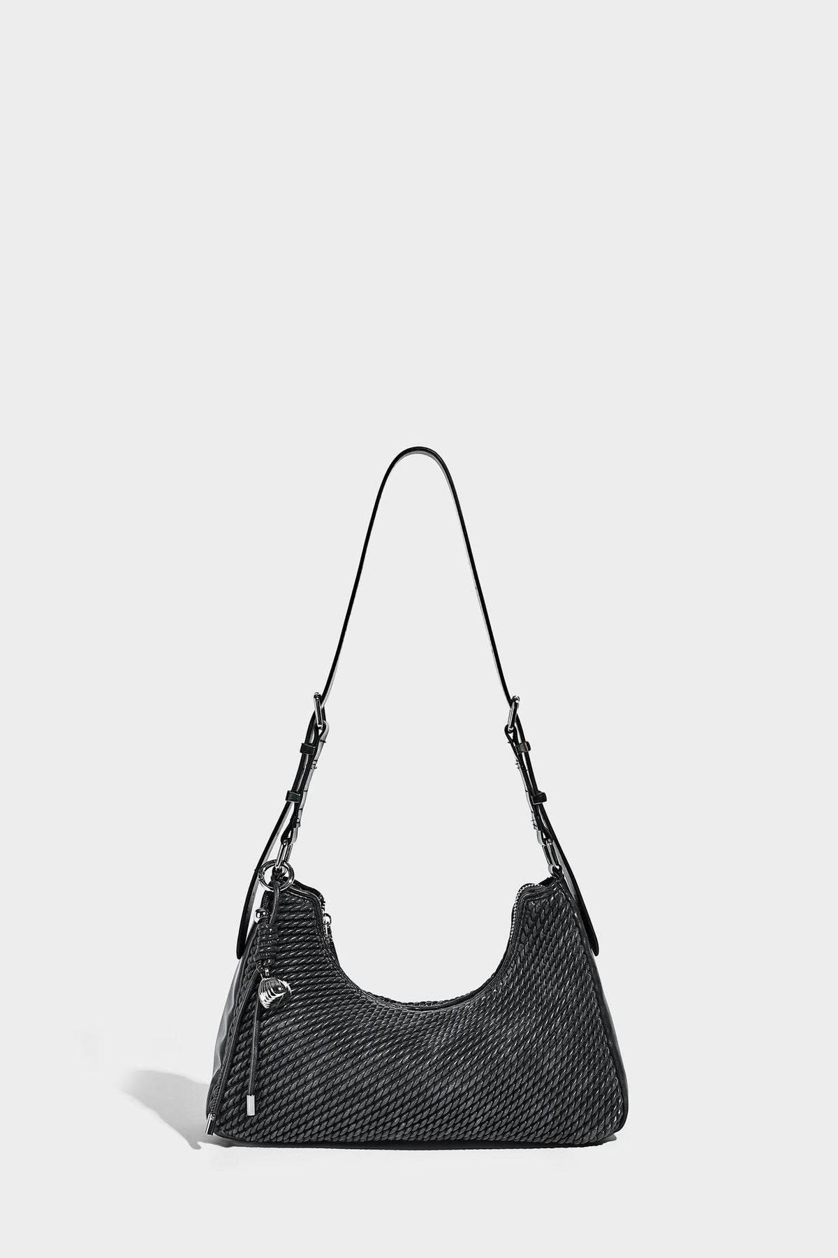 Woven crescent hobo shoulder bag with smooth side panels, zip-top closure, silver-tone charm hardware, and adjustable, detail