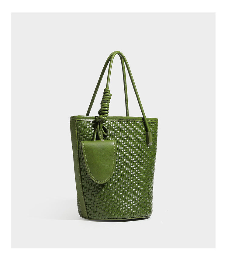 Structured woven-texture leather-look bucket bag in brown with knotted top handles, small front flap pouch, and adjustable