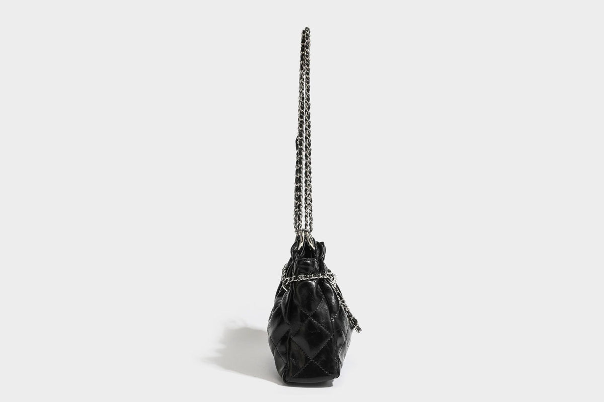 Glossy diamond-quilted drawstring bucket bag with silver chain shoulder strap and medallion charm, detail view 29