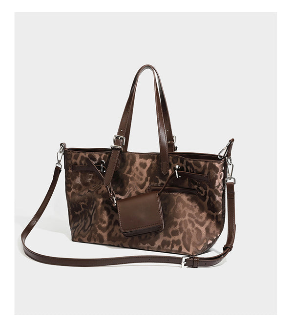 Glossy leopard-print tote bag with leather-look dark trim, dual top handles, detachable shoulder strap, and attached front