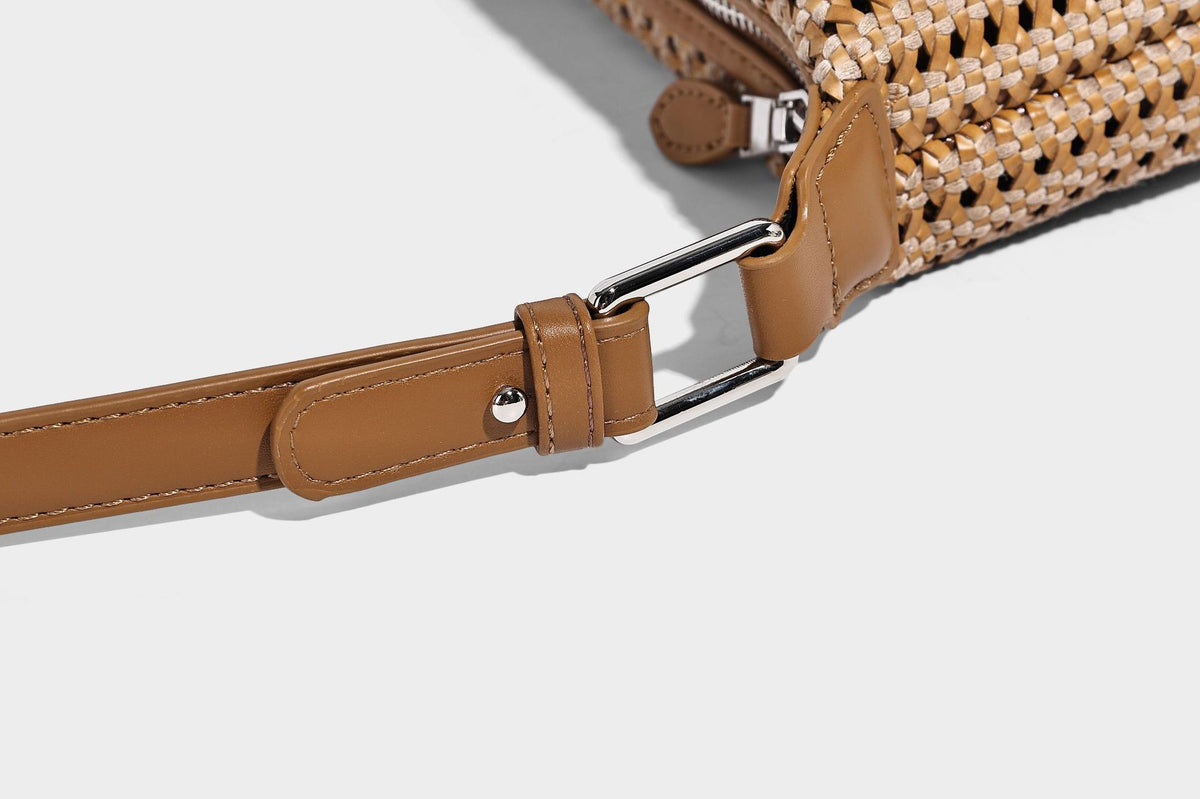 Woven crescent shoulder bag with leather-look knotted handle, zip top, attached mini pouch, and silver-tone hardware, detail