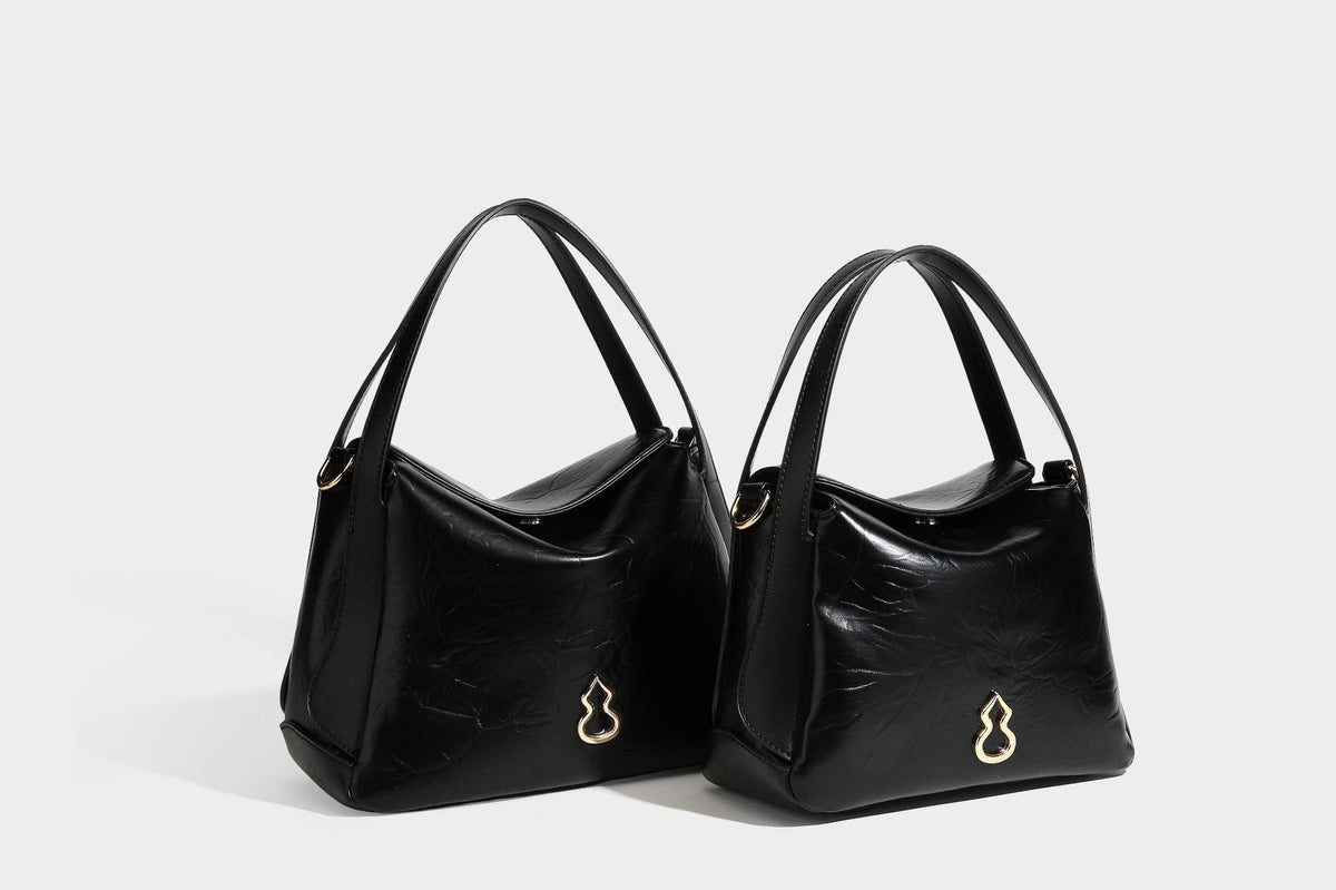 Glänzende, geknautschte Henkeltasche in Lederoptik mit goldfarbenen Emblem-Details und abnehmbarem Schulterriemen, Detailansicht 27