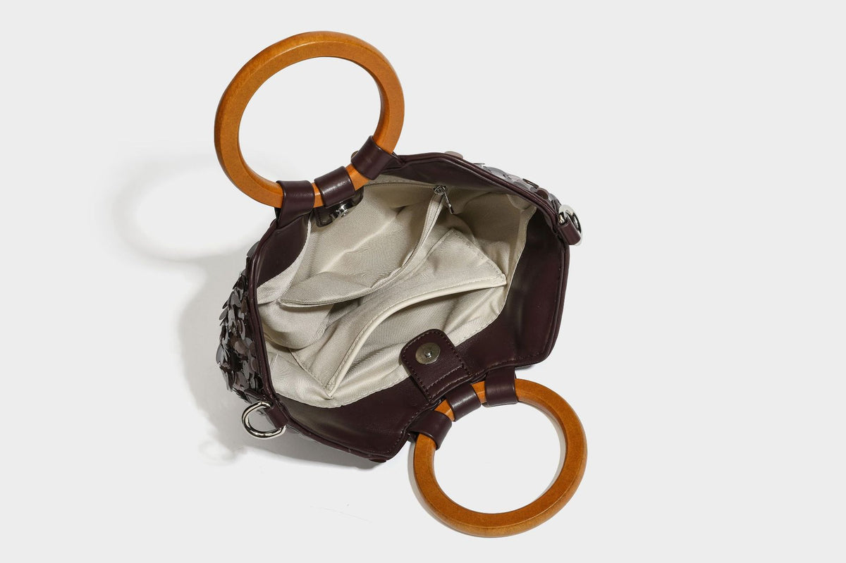 Small sequin half-moon handbag with circular wood-look ring handles and detachable leather-look shoulder strap, detail view