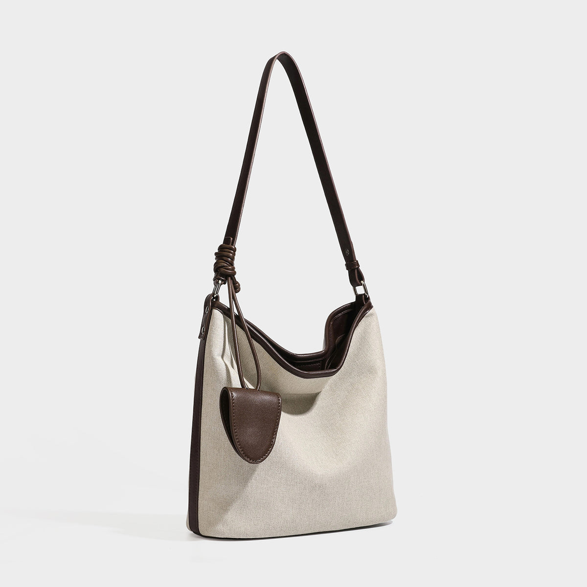 Schulter-Shopper aus haferbeigem Canvas mit dunkelbrauner Kunstleder-Optik, langem verstellbarem Riemen und aufgesetzter Mini-Tasche mit Überschlag, Detailansicht
