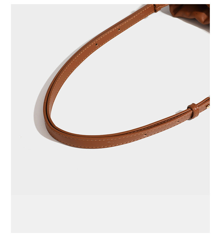 Suede-look drawstring shoulder bag in brown with smooth trim, knotted bead drawstring closure, slim adjustable strap, and