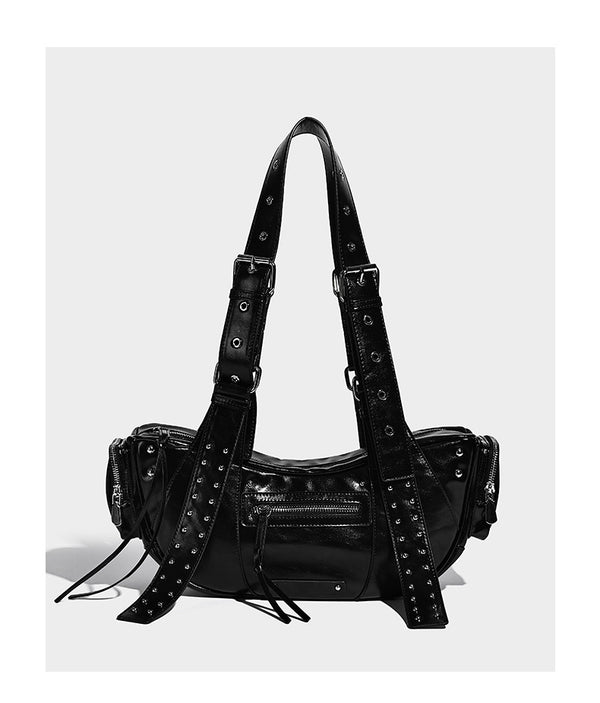 Glossy black crescent shoulder bag with silver-tone rivets, multiple zip pockets, and long adjustable studded straps, detail