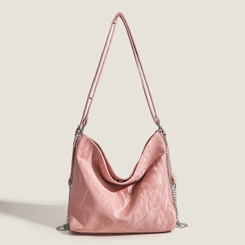 Blush pink slouchy hobo bag with crinkled sheen finish, silver-tone chain hardware, and adjustable shoulder strap, front view