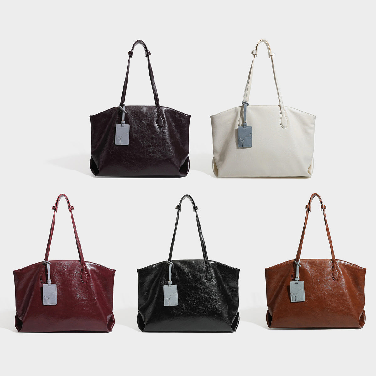 Oversized-Shopper mit lässig-weicher Form in dunkler Burgunderfarbe, glänzender geknautschter Lederoptik, zwei langen Schulterriemen und kontrastierendem