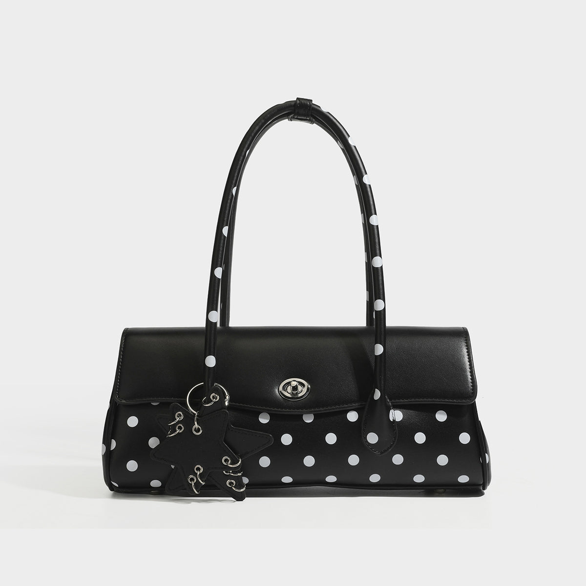 Formstabile Baguette-Tasche mit Polka-Dot-Muster, glänzender Oberfläche in Lederoptik, zwei Tragegriffen, silberfarbenem Drehverschluss an der Umschlagklappe und