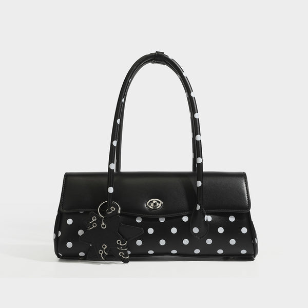 Formstabile Baguette-Tasche mit Polka-Dot-Muster, glänzender Oberfläche in Lederoptik, zwei Tragegriffen, silberfarbenem Drehverschluss an der Umschlagklappe und