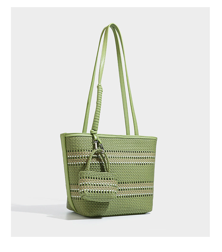 Large structured woven tote bag with striped basket-weave finish, long shoulder straps, and detachable mini pouch charm