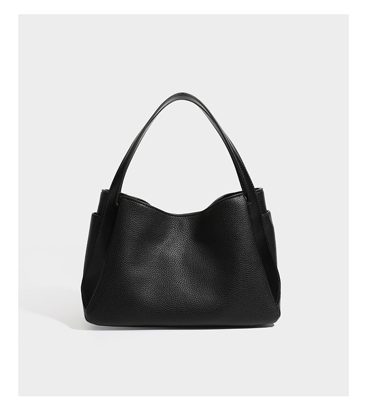 Schwarze Tote-Bag aus genarbtem Material in Lederoptik mit kürbisförmigen Beschlägen in Goldoptik, zwei Henkeln und abnehmbarem Umhängeriemen, Detailansicht