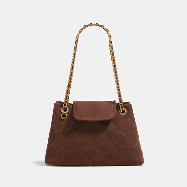 Quilted trapezoid shoulder bag with chain straps, flap closure, and ring hardware, detail view 7
