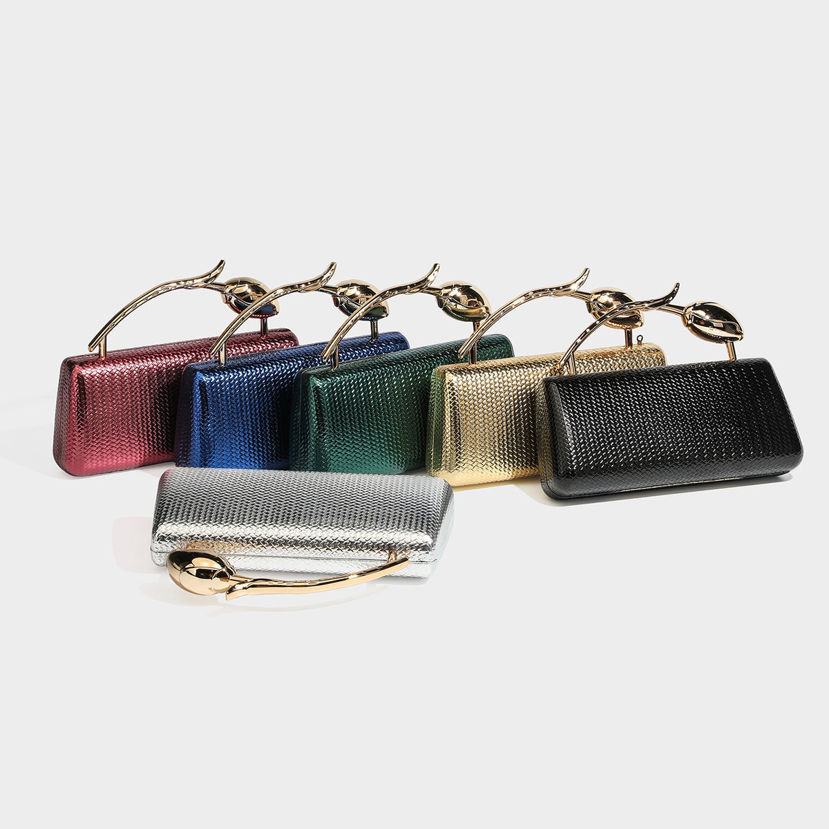 Structured rectangular metallic woven clutch bag with sculptural gold-tone leaf top handle and detachable chain strap, detail