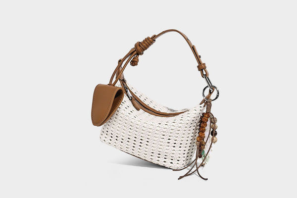 Woven crescent shoulder bag with leather-look knotted handle, zip top, attached mini pouch, and silver-tone hardware, detail