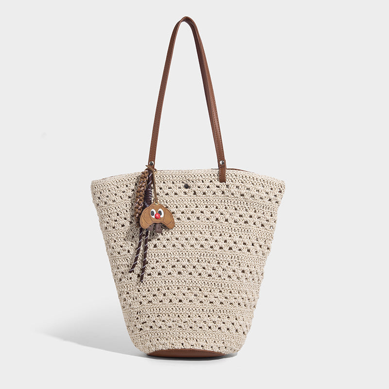 Open-weave crochet tote bag with brown leather-look shoulder straps and base trim, front view