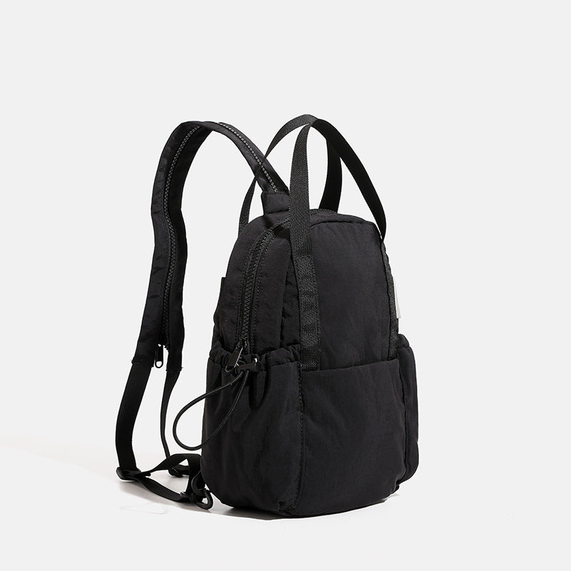 Mini rounded convertible backpack handbag in matte ripstop fabric with dual top handles, adjustable straps, and side, detail
