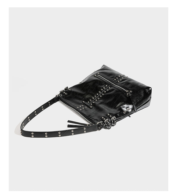 Black glossy leather-look slouchy shoulder bag with silver stud and eyelet hardware, top zip closure, front zip pocket, and