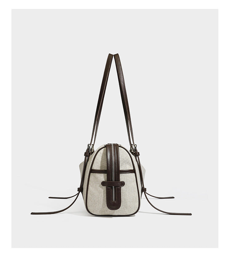 Cream canvas barrel shoulder bag with dark brown leather-look straps, trim, and silver-tone hardware, detail view 10