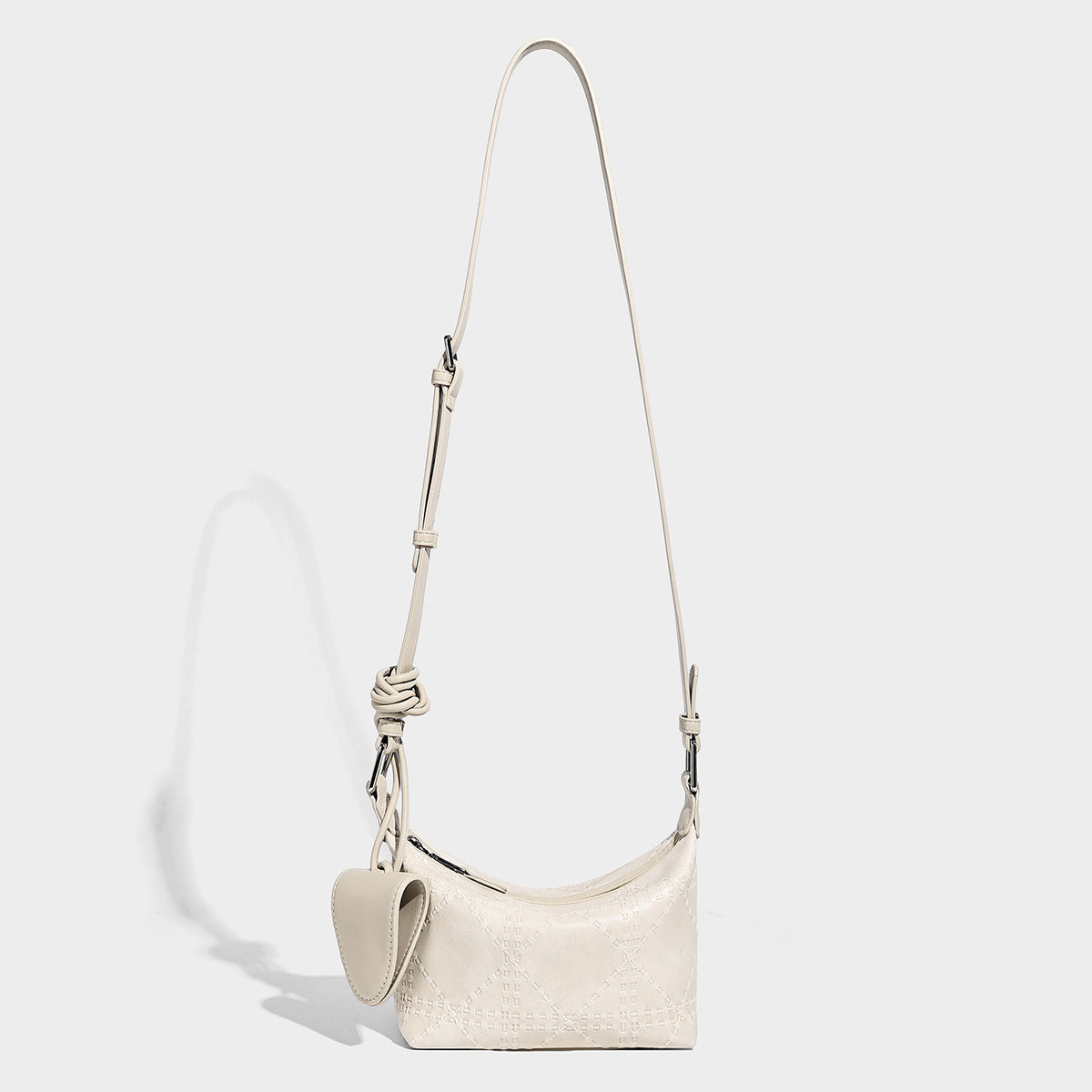 Small embossed half-moon shoulder bag with top zipper, detachable front pouch, and adjustable slim strap, detail view 4