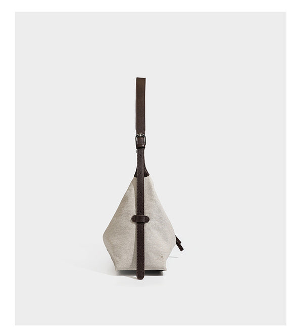 Lässig geschnittene Hobo-Schultertasche aus Canvas in Haferflockenfarbe mit dunkelbraunem Besatz in Lederoptik, silberfarbenem Reißverschluss und langem, verstellbarem