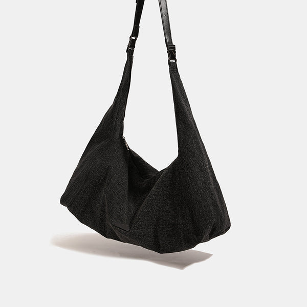 Oversized slouchy hobo shoulder bag in dark marled denim-texture fabric with top zip closure and adjustable single strap