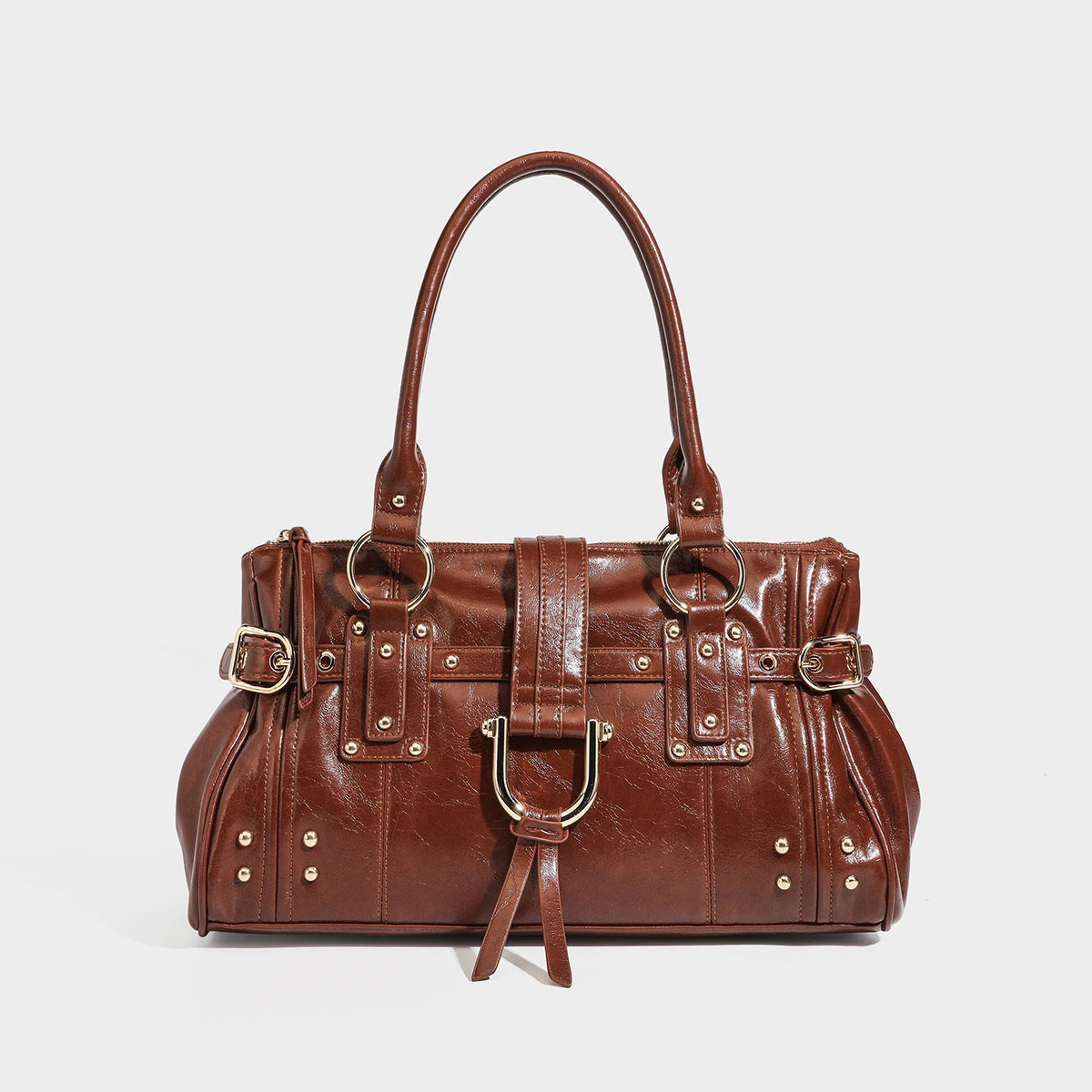 Dark brown glossy leather-look structured satchel tote with gold-tone studs, buckle straps, dual top handles, and detachable