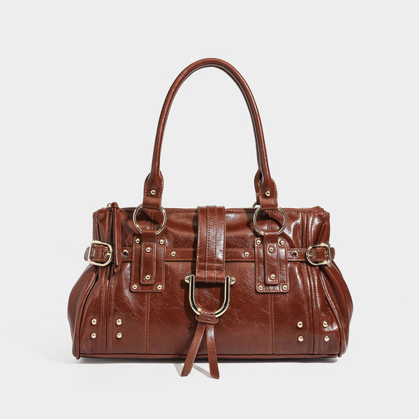 Dark brown glossy leather-look structured satchel tote with gold-tone studs, buckle straps, dual top handles, and detachable