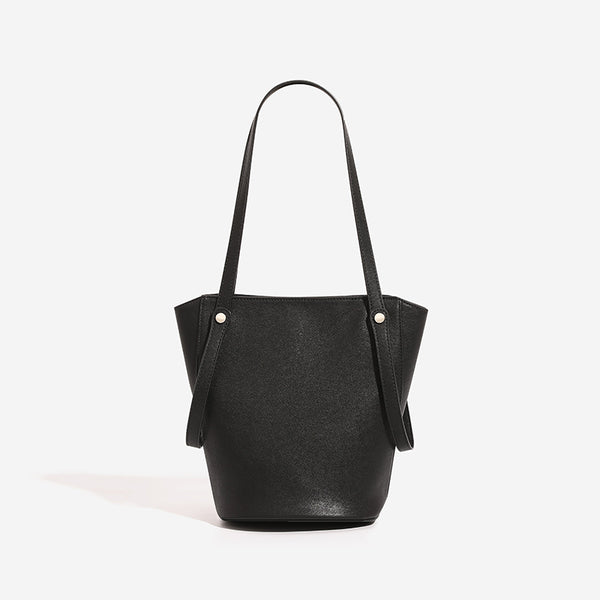 Structured black leather-look bucket tote bag with slim shoulder straps, silver-tone stud hardware, and tapered body, detail