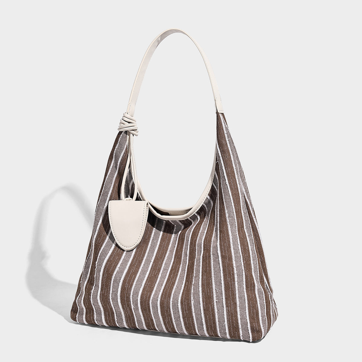 Lässig fallende gestreifte Hobo-Schultertasche aus Canvas mit Besatz in Creme und langem geknotetem Trageriemen, Vorderansicht