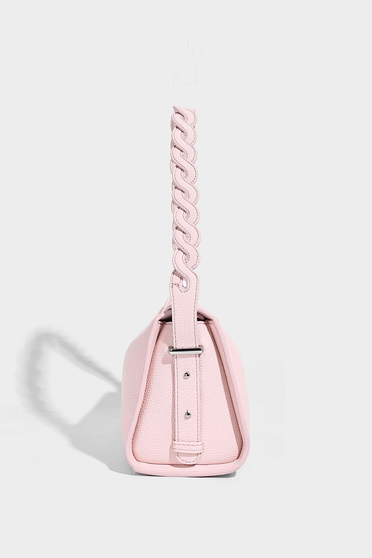 Small structured pebbled-finish shoulder bag with braided top handle, detachable crossbody strap, floral tassel charm, and