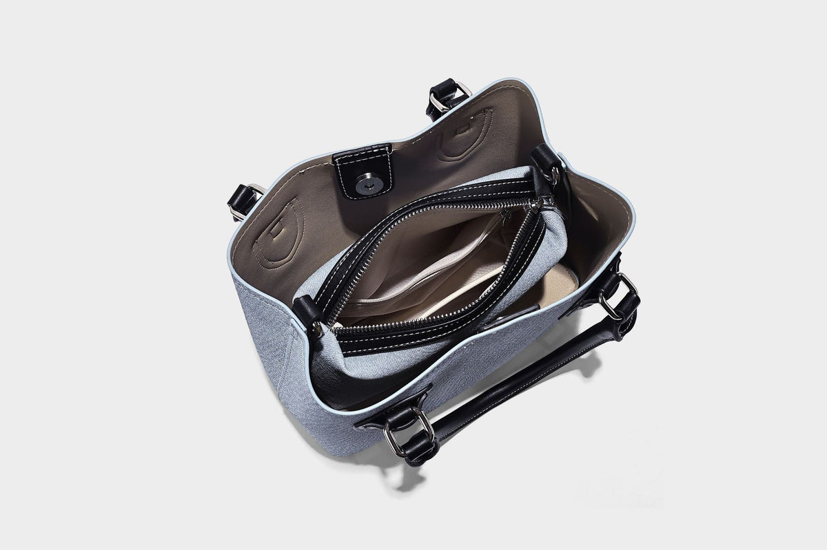 Structured light-blue denim-look tote bag with black leather-look handles, white contrast stitching, silver-tone hardware