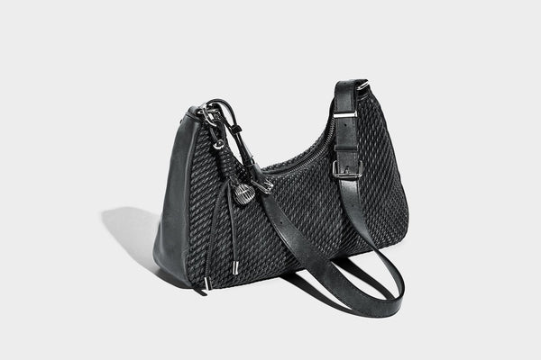 Woven crescent hobo shoulder bag with smooth side panels, zip-top closure, silver-tone charm hardware, and adjustable, detail