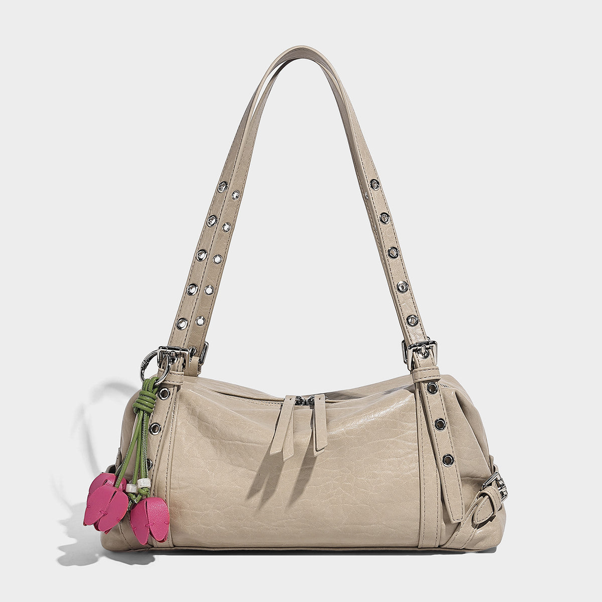 Pale yellow leather-look barrel bag with silver grommet-studded shoulder straps, top zip closure, and pink tulip floral