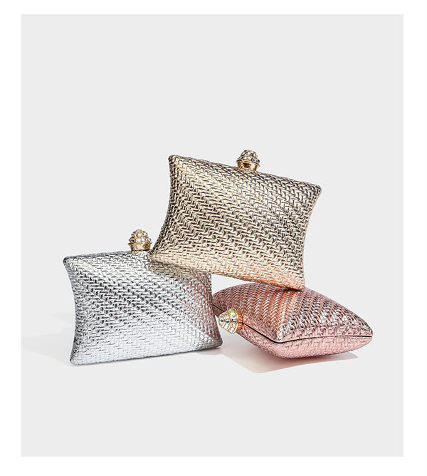 Small structured rectangular metallic woven-texture clutch bag with jeweled knob clasp and gold-tone chain strap, detail view