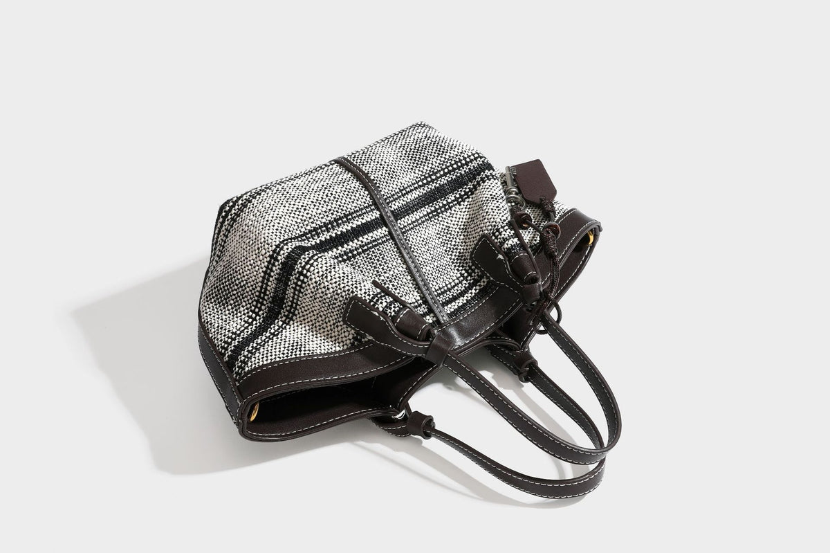 Schwarz-weiße gewebte Trapez-Tote-Bag mit dunklem Lederimitat-Besatz, weißen Kontrastnähten und zwei Henkeln, Detailansicht