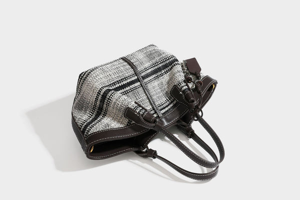 Schwarz-weiße gewebte Trapez-Tote-Bag mit dunklem Lederimitat-Besatz, weißen Kontrastnähten und zwei Henkeln, Detailansicht