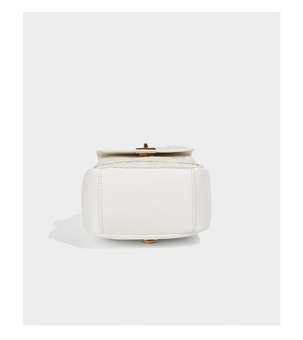 Structured mini backpack handbag with butterfly embroidery, gold-tone chain strap, and turn-lock front flap pocket, detail