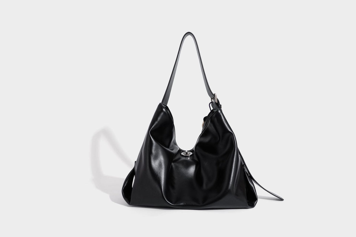 Große schwarze, glänzende Hobo-Schultertasche in Lederoptik mit mit Ösen besetztem Riemen, silberfarbenen Beschlägen und abnehmbarem