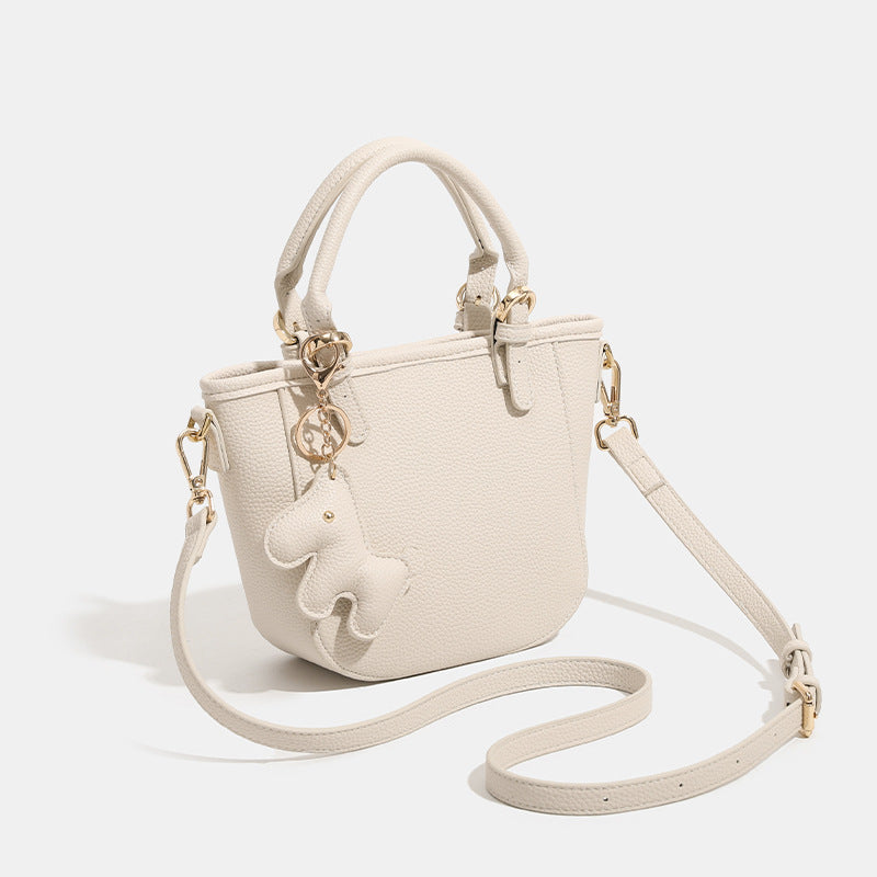 Mini-Bucket-Tote-Bag mit strukturierter Form und matter, genarbter Oberfläche, Pferdeanhänger, zwei Tragegriffen und abnehmbarem Schulterriemen