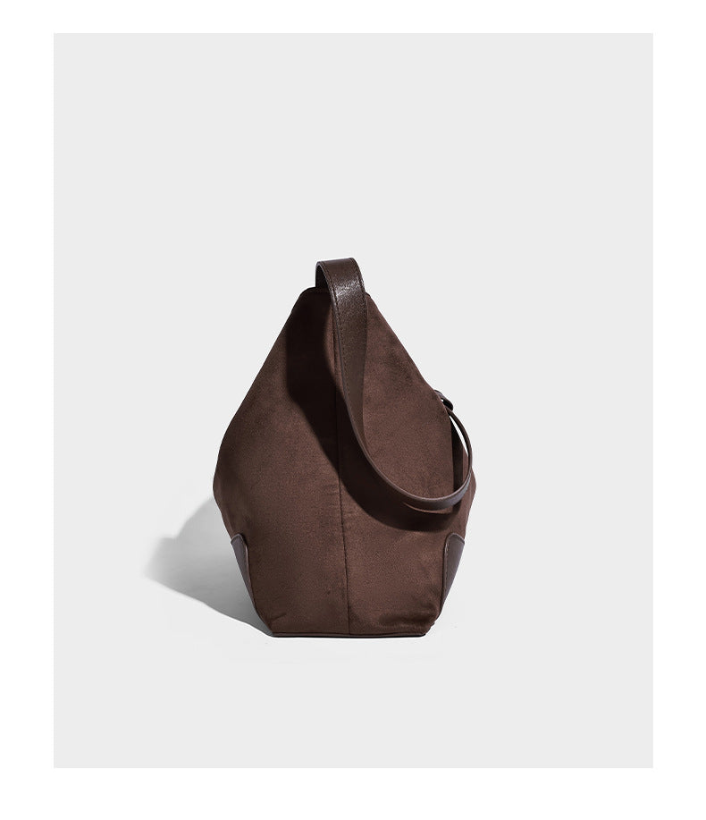 Dark brown slouchy hobo bag with matte suede-look body, smooth leather-look base trim, adjustable shoulder strap, and, detail