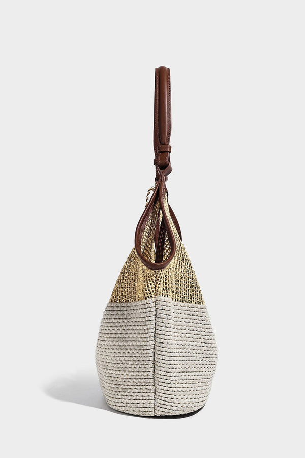 Two-tone beige and cream woven straw hobo shoulder bag with brown leather-look trim, long shoulder strap, and tassel-bead
