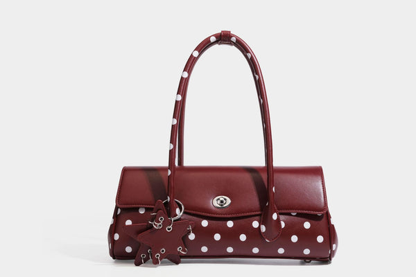 Strukturierte Baguette-Tasche mit Polka-Dot-Muster, glänzender Lederoptik, zwei Tragegriffen, silberfarbener Drehverschlussklappe und