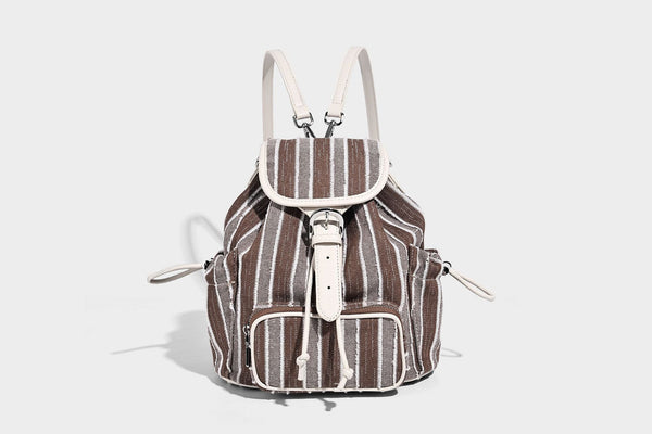 Weicher Rucksack aus gewebtem Material mit vertikalen Streifen, Überschlag, Kordelzug, vorderer Reißverschlusstasche, weißen Besätzen und Trägern in Lederoptik, Detailansicht