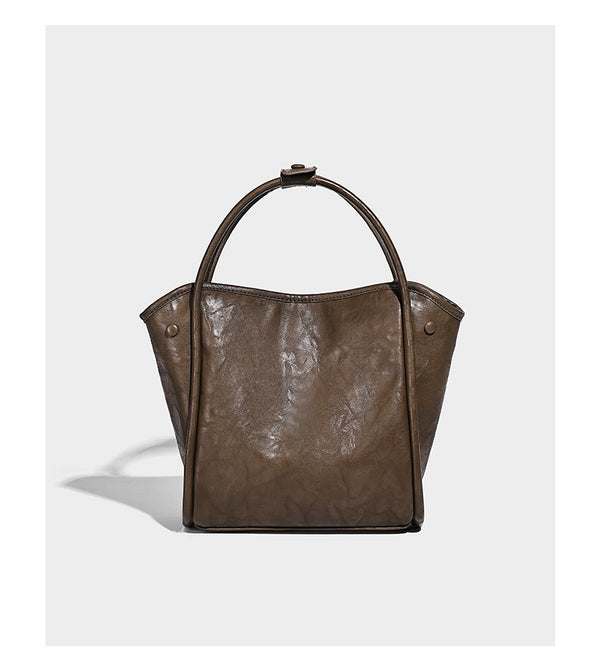 Glänzende Tote-Bag in geknautschter Lederoptik mit geprägtem rundem Emblem, Quastenschnürung, zwei Henkeln und abnehmbarem