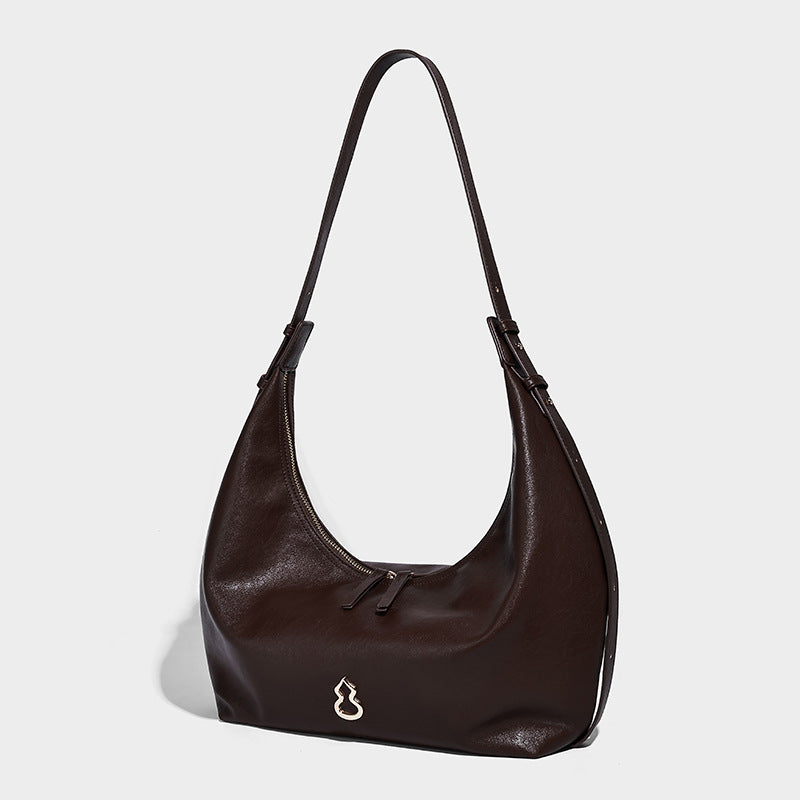 Weiche, sichelförmige Hobo-Schultertasche in dunkelbrauner glatter Lederoptik mit Logo-Anhänger in Goldoptik und verstellbarem Riemen