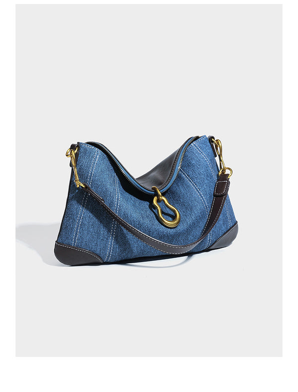 Slouchy denim shoulder bag with dark leather-look trim, gold-tone chain-link hardware, and top zipper closure, detail view 7