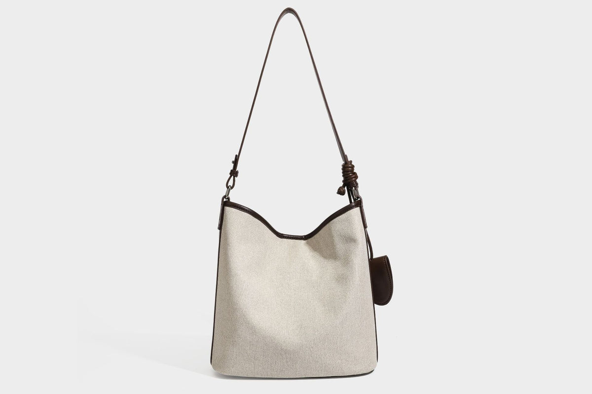 Oatfarbene Canvas-Schultertasche mit dunkelbraunem Besatz in Lederoptik, langem verstellbarem Riemen und angebrachter Mini-Tasche mit Überschlag, Detailansicht