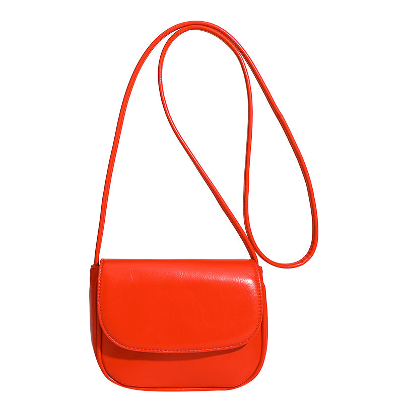 Compact rounded rectangular flap crossbody bag with glossy leather-look finish and long shoulder strap, detail view 5