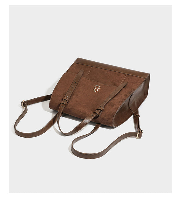 Structured suede-look convertible backpack handbag with flap closure and gold-tone emblem hardware in chocolate brown, detail